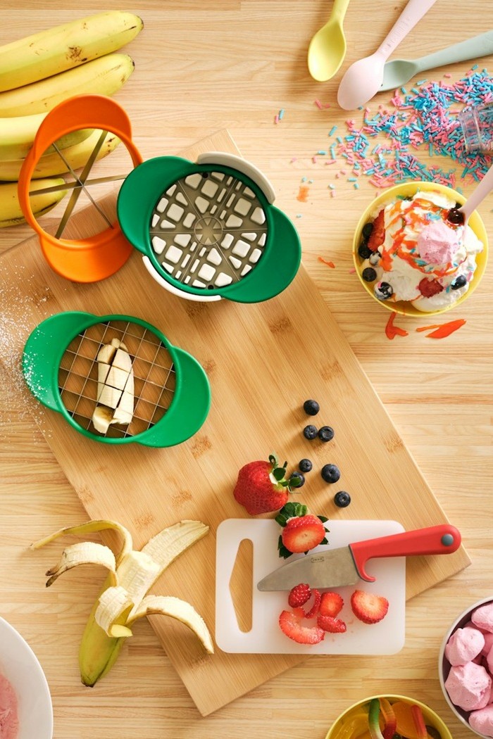 Colourful UPPFYLLD fruit cutters on a table with sliced fruits and snacks.