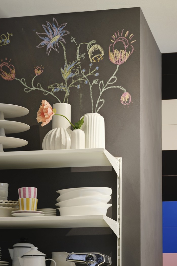 Open kitchen shelves mounted to the wall with neatly arranged plates, bowls and decor items.