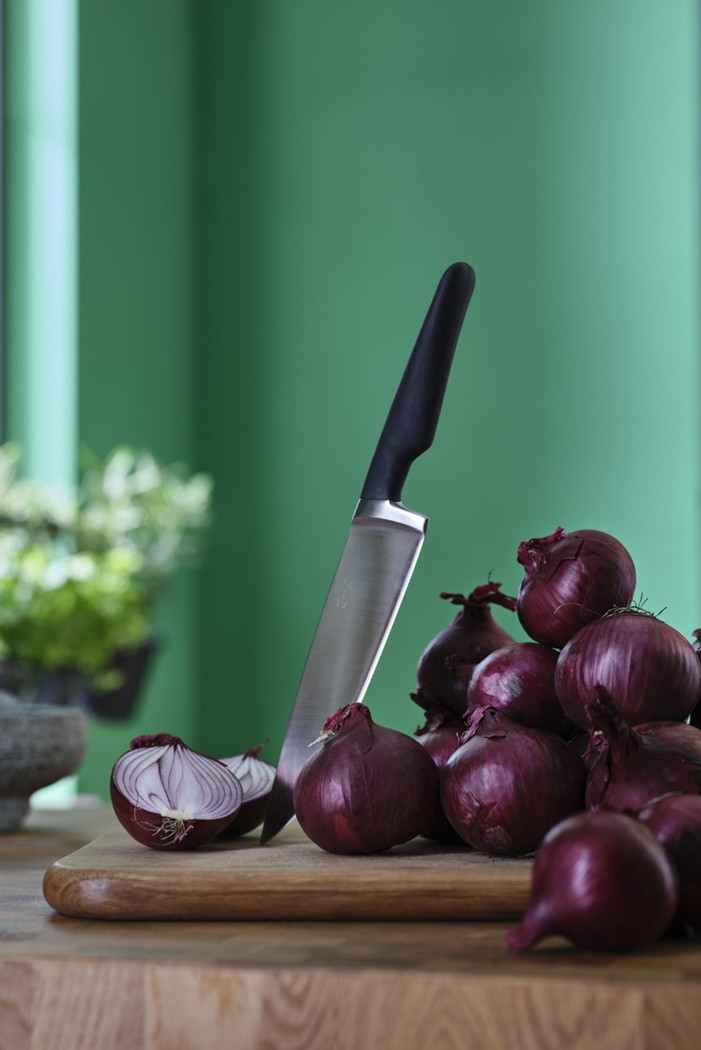 VARDAGEN cook's knife on a cutting board beside sliced red onions.