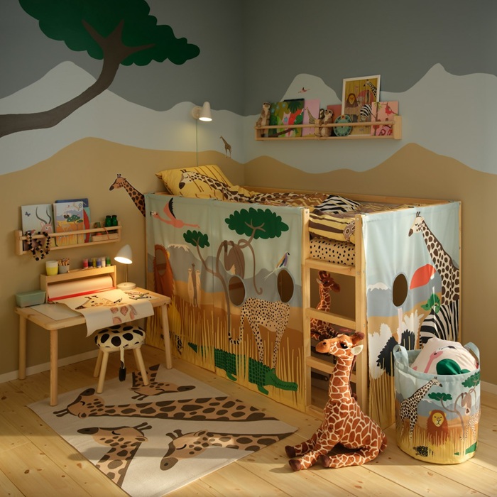 A children’s room filled with savannah themed toys from the SANDLÖPARE collection with giraffes on both rug and bedding.