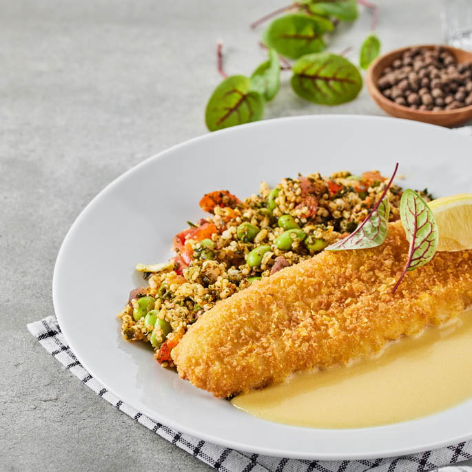 Dish at the Swedish Restaurant: cod in breadcrumbs with a side dish of vegetables and grains, along with white wine sauce