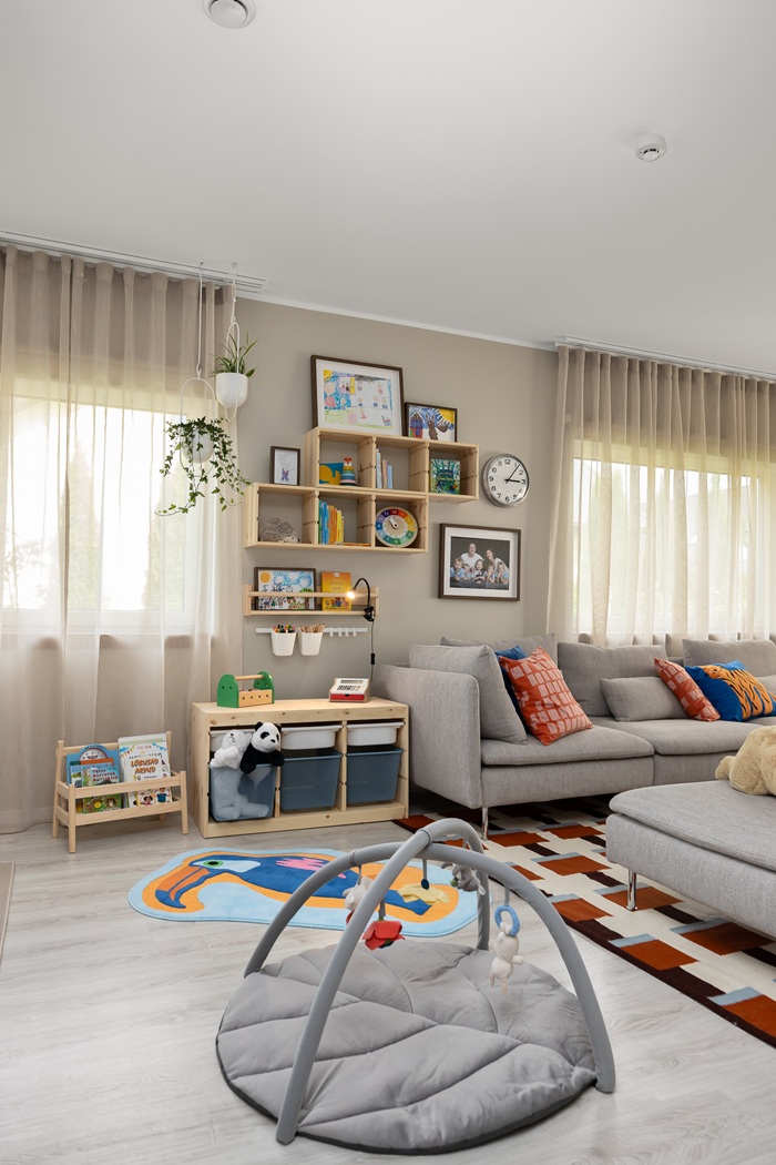 A grey play mat in front of a play zone tih TROFAST storage in a living room dotted with dashes of color.