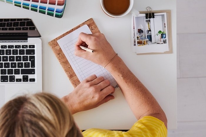 Top view of an interior designer holding pictures with interior design ideas.