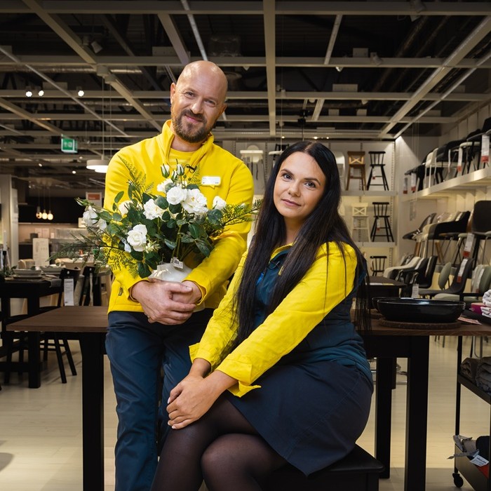Two IKEA experts standing in the store, wearing blue and yellow uniforms.