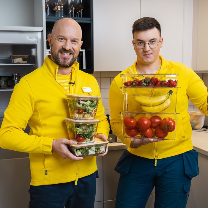 Two IKEA experts standing in the store, wearing blue and yellow uniforms.