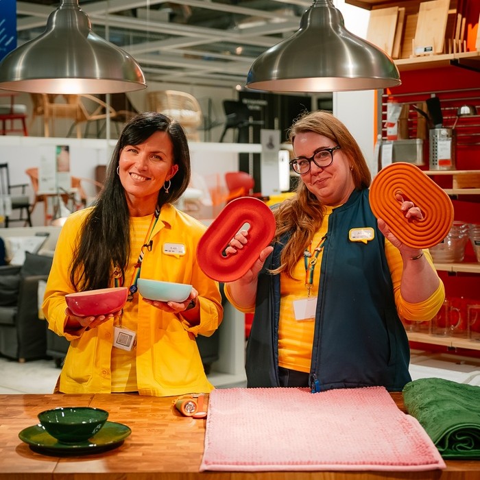 Two cheerful IKEA experts in a colorful children´s room setting.
