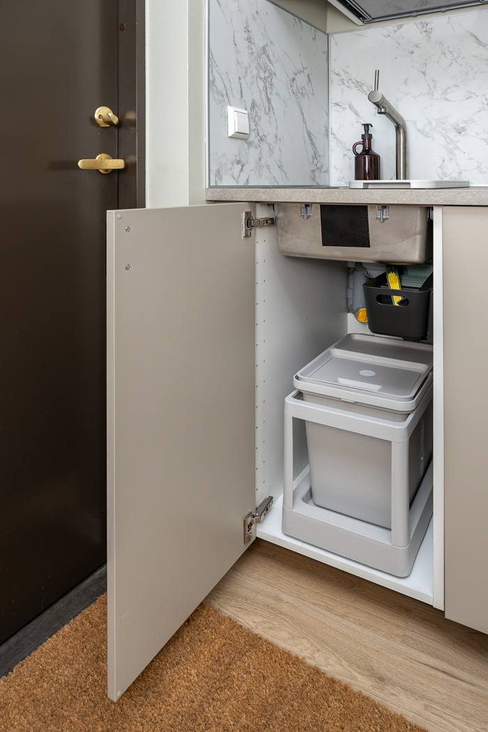 Valamu all asuv prügisortimissüsteem on näha, sest kapiuks on lahti.