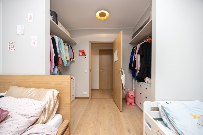 Piklik heledates toonides lastetuba, mille mõlemas servas on voodi ja otsaseinas avatud puidutoonis uks. Toa kaugemas otsas on mõlemal pool seina ääres panipaik riietele.