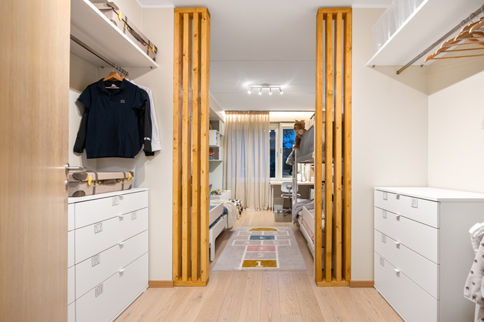 Lastetuba garderoobiosa poolt. Puitribid jaotavad heledates toonides ruumi garderoobiosaks ja magamisosaks. 