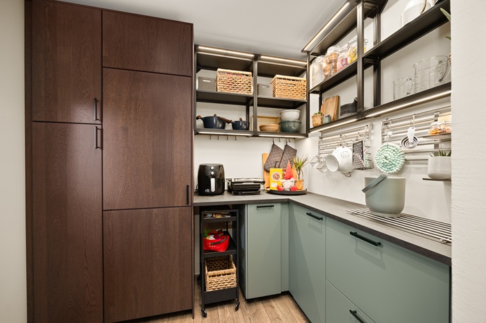 Heleda põranda ja pooleldi siniseks, pooleldi valgeks värvitud toas on sinise voodipesuga voodi ja akna all mängimislaud puidust raudteega, Laua ees on kaks sebrataburetti. 