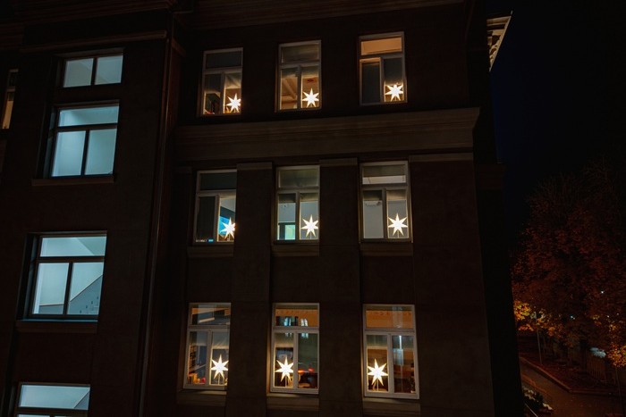 A close-up of nine windows with STRÅLA stars shining in the dark.