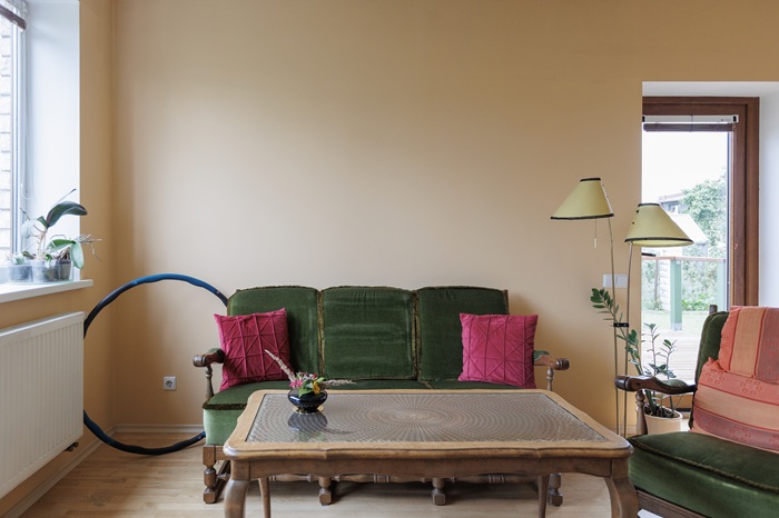 Обеденная зона до преображения: круглый стол с белой скатертью и три деревянных стула с узорной тканевой обивкой.