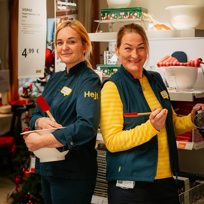 Two cheerful IKEA experts in a colorful children´s room setting.