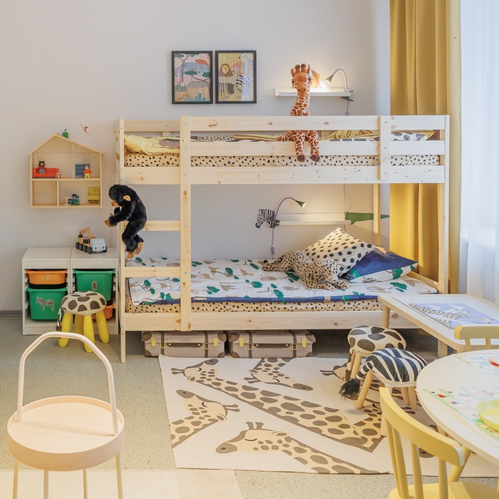 Šeimos kambarys iš kito kampo: be kitų išvardytų baldų, jame matosi medinė dviaukštė lova vaikams. 