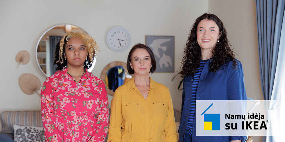 A mother in a yellow dress, daughter in a red floral dress and an IKEA interior designer in a blue uniform sitting together on a sofa.