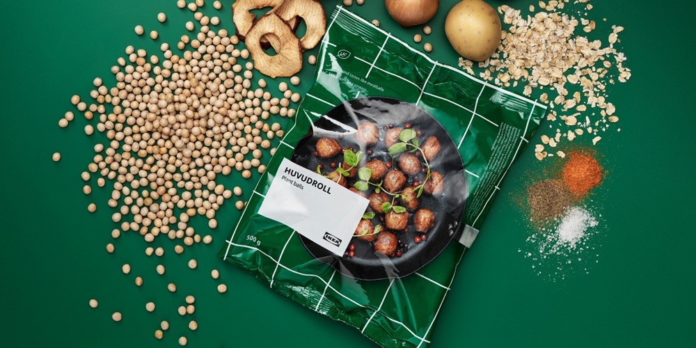 Package of HUVUDROLL frozen plant balls on a dark green background, surrounded by the ingredients used to make them.
