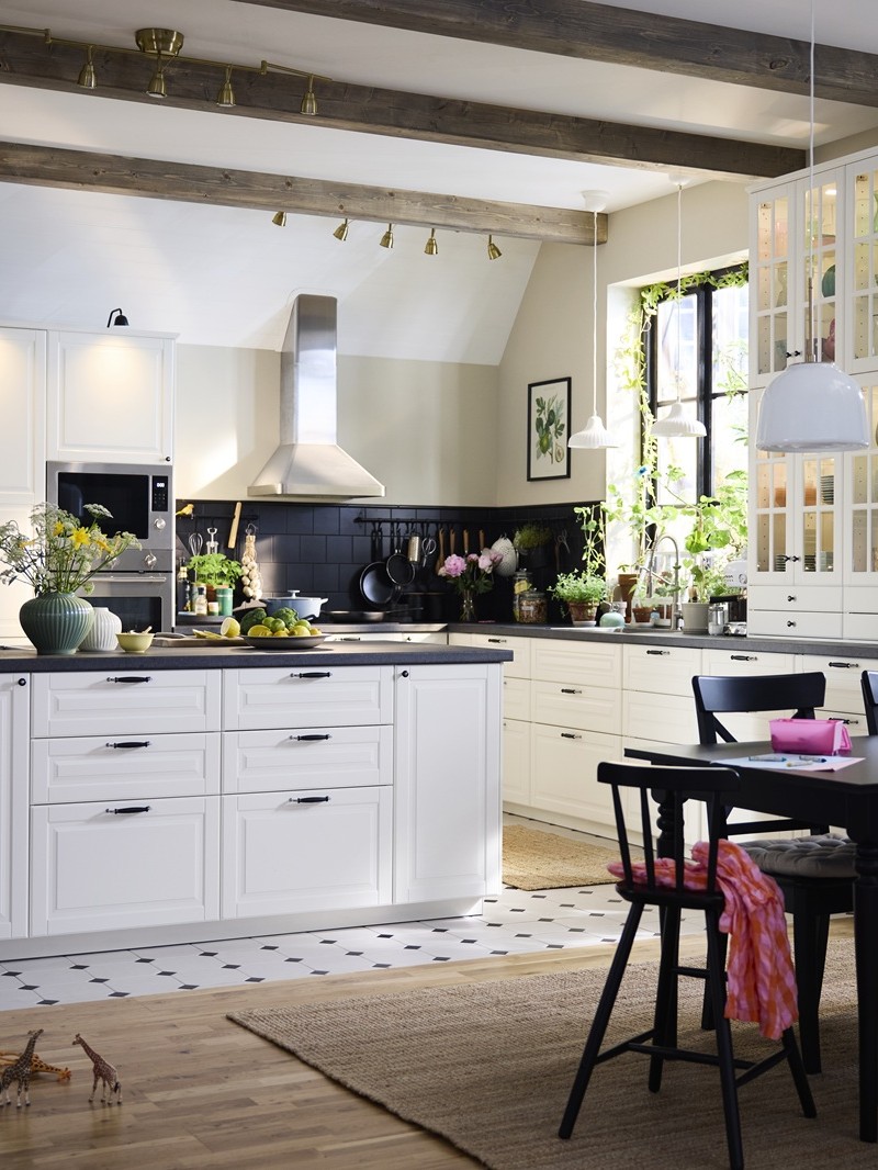 Suur traditsioonilises stiilis valgete BODBYN esipaneelidega köök koos köögisaare ja tumeda puidust söögialakomplektiga.